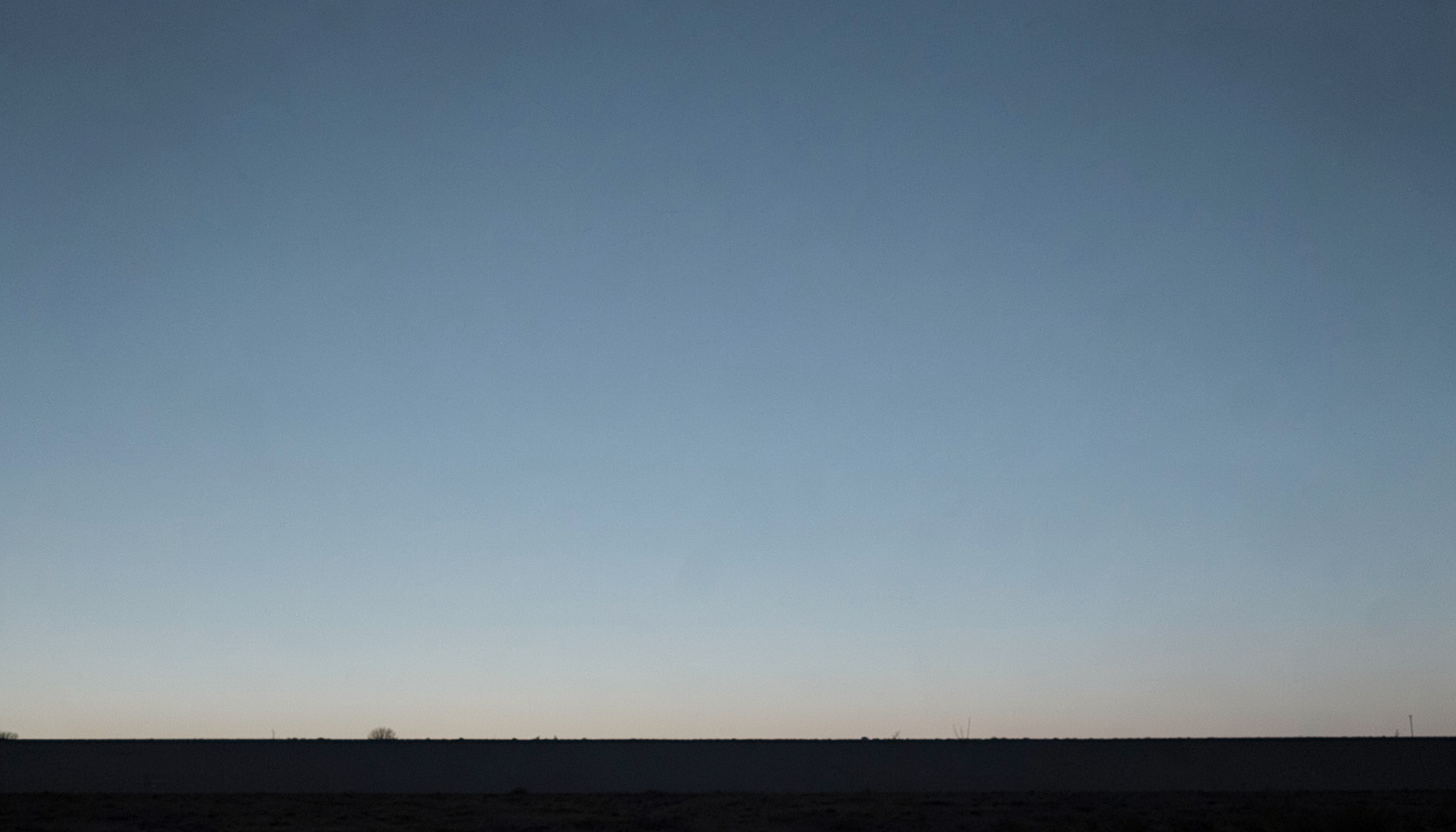 A muted slate-blue gradient sky above a charcoal horizon, evoking a calm, technical mood for an Android blog header.